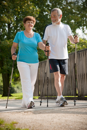 Foto mit Frau und Mann mit Walkingstöcken laufend